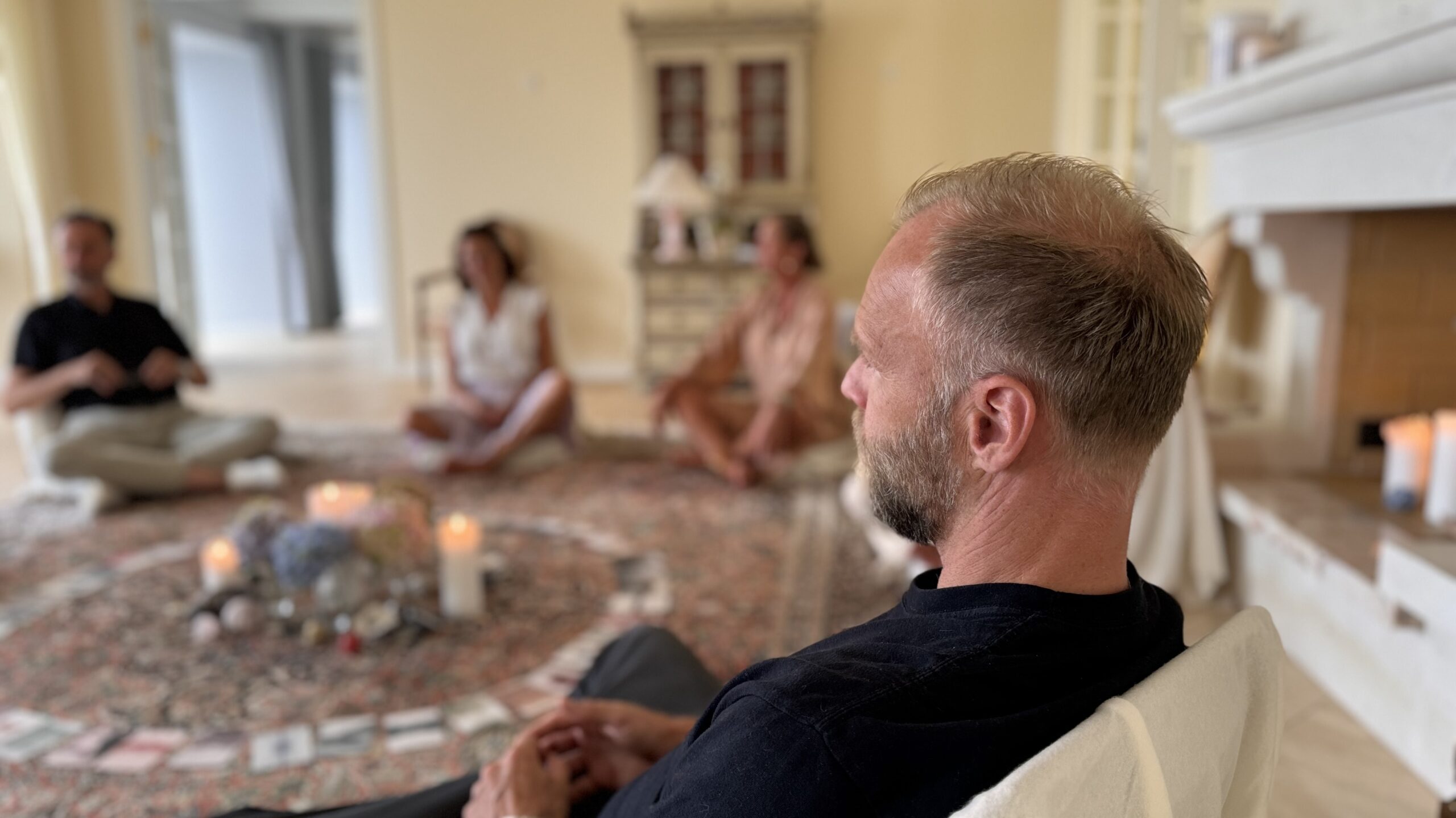Mennesker sidder i en cirkel omkring et alter og deler